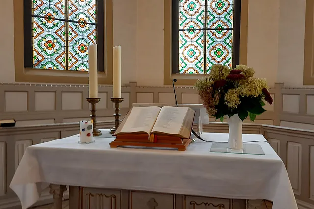 Altar mit Bibel, Blumen und Kerzen