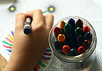 Buntstifte und eine malende Hand