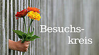 Hand reicht Blumen durch Vorhang