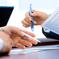 Hände, die mit einem Stift Formulare ausfüllen